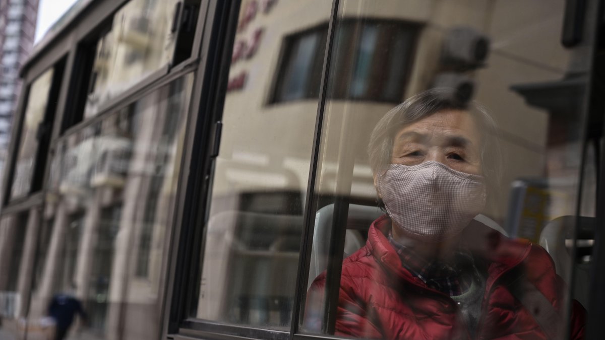Una mujer que llevaba una máscara facial viaja en un autobús en Shangai el 2 de marzo de 2020. El número global de muertos por la nueva epidemia de coronavirus superó los 3.000.