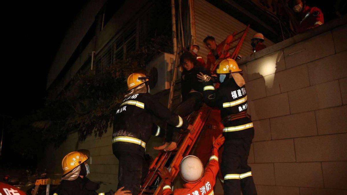 Los equipos de rescate sacan a una mujer herida de los escombros.