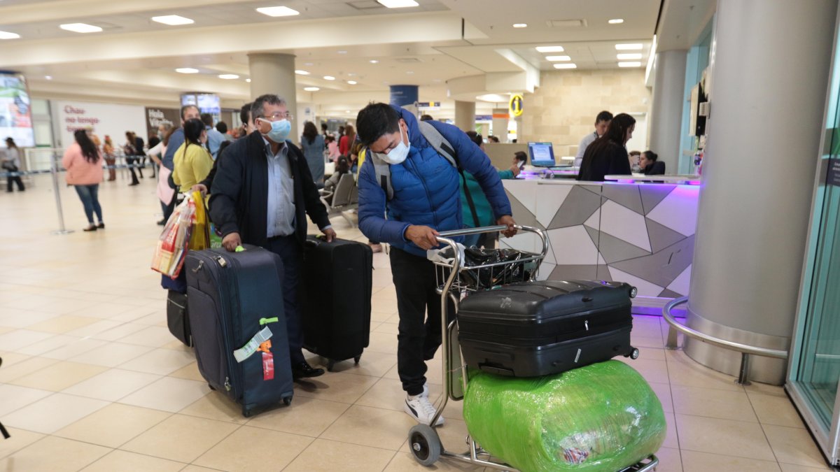 Pasajeros llegan con mascarillas al aeropuerto de Tababela, Quito.