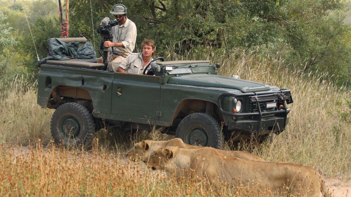 Brent Leo-Smith (d) y su operador de cámara, Andrew (i), filman una manada de leones en la reserva privada de Djuma (Sudáfrica), para los safaris virtuales.