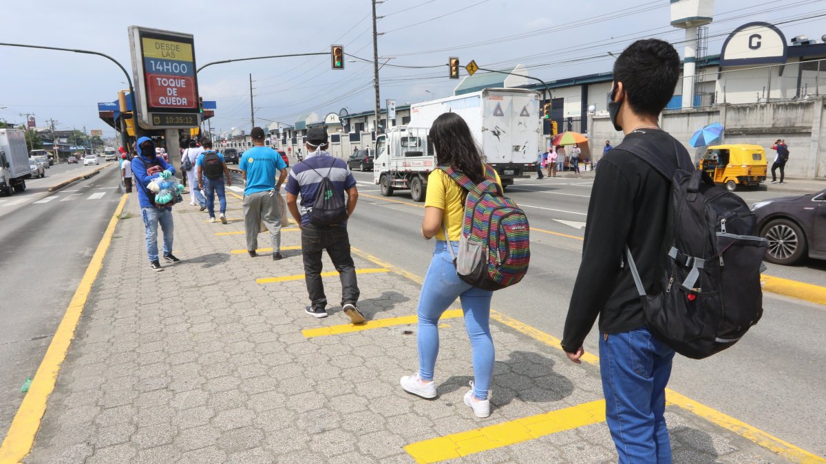 Prevención. Usuarios de la metrovía, en Guayaquil, hacen fila con el distanciamiento marcado.