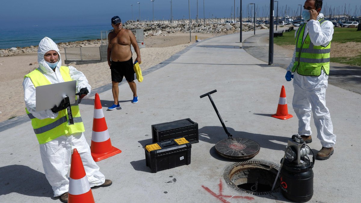 ASHKELON. Técnicos de la firma israelí Kando extraen muestras de aguas residuales de una boca de inspección cerca de la playa de esta ciudad balnerario.