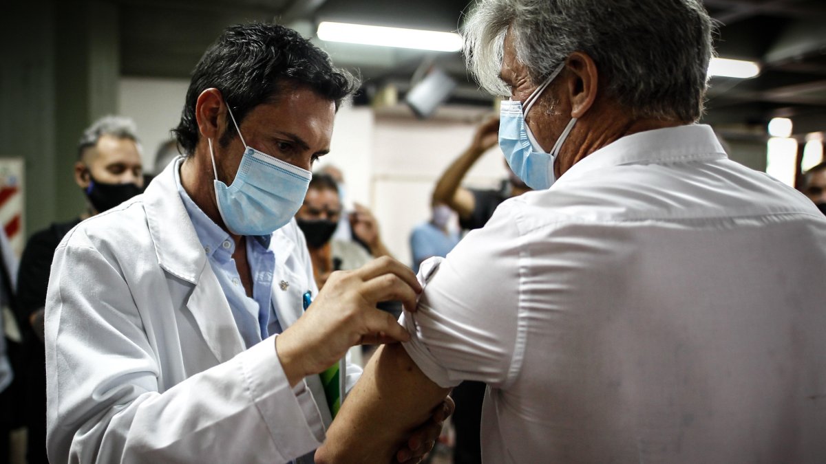 Un hombre es vacunado hoy contra la covid-19 en el Hospital Fiorito, en Avellaneda (Argentina).