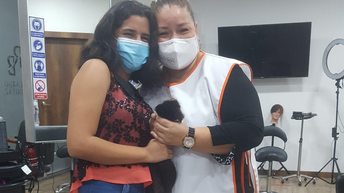 Marvelys Velasco entrega su cabello a Jéssica Camejo, que dirige la fundación Fuerza Dorian.