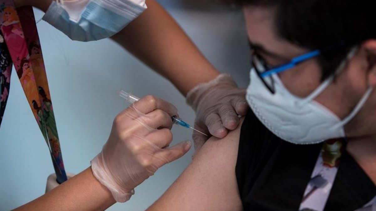 Un trabajador sanitario recibe la vacuna contra la covid-19, en el Hospital de Urgencia Asistencia Pública en Santiago (Chile).
