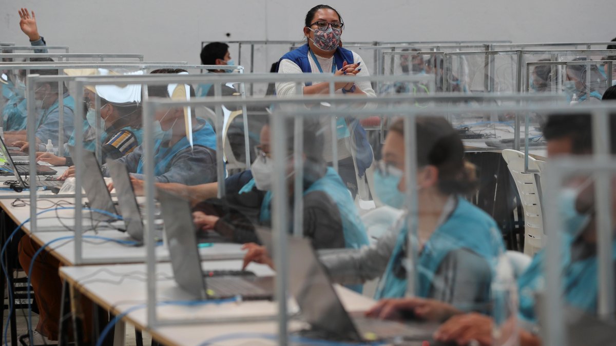 Personas trabajan en la delegación Provincial de Pichincha del Consejo Nacional Electoral ecuatoriano, donde se reciben las actas con los resultados de las elecciones presidenciales 2021, en Quito.