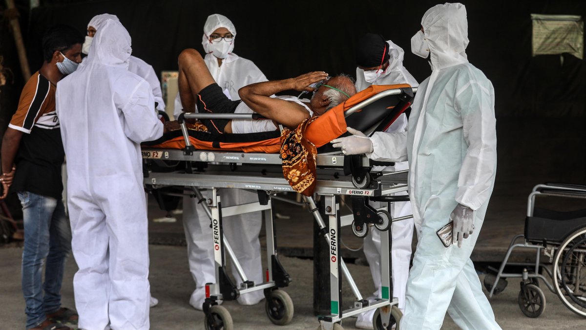 Los trabajadores sanitarios atienden a un paciente sospechoso de covid-19 que espera fuera del centro de salud Covid-19 en Mumbai, India, el 19 de abril de 2021.