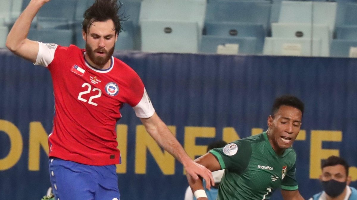 Ben Brereton de Chile disputa hoy el balón con Jairo Quinteros de Bolivia.