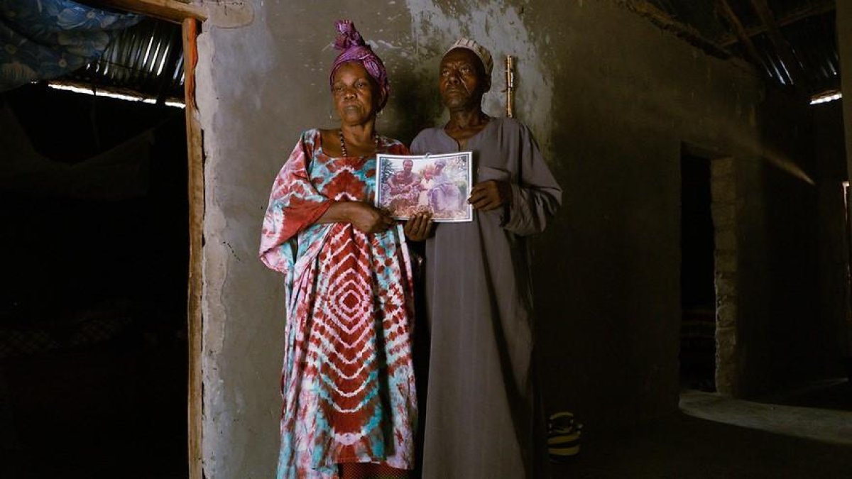 Los padres de Aliou Candé, con una foto familiar, en Guinea Bissau en mayo de 2021.