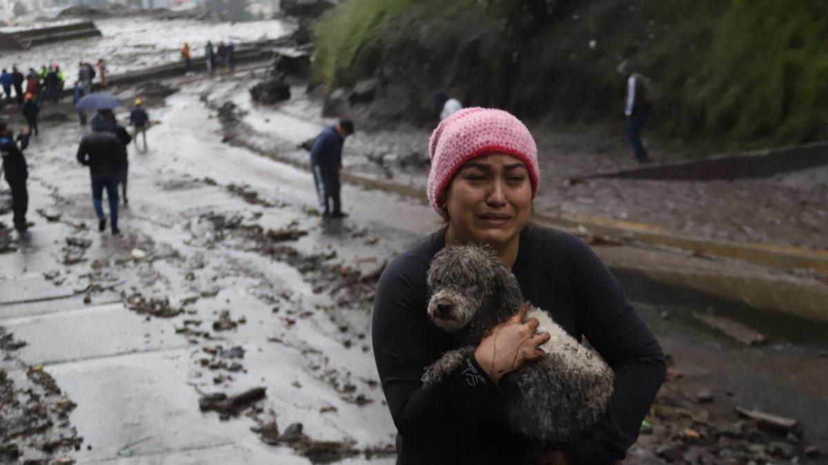 Mascota rescatada. Una mujer camina con su perra, luego de encontrarla a salvo en una vivienda aledaña.