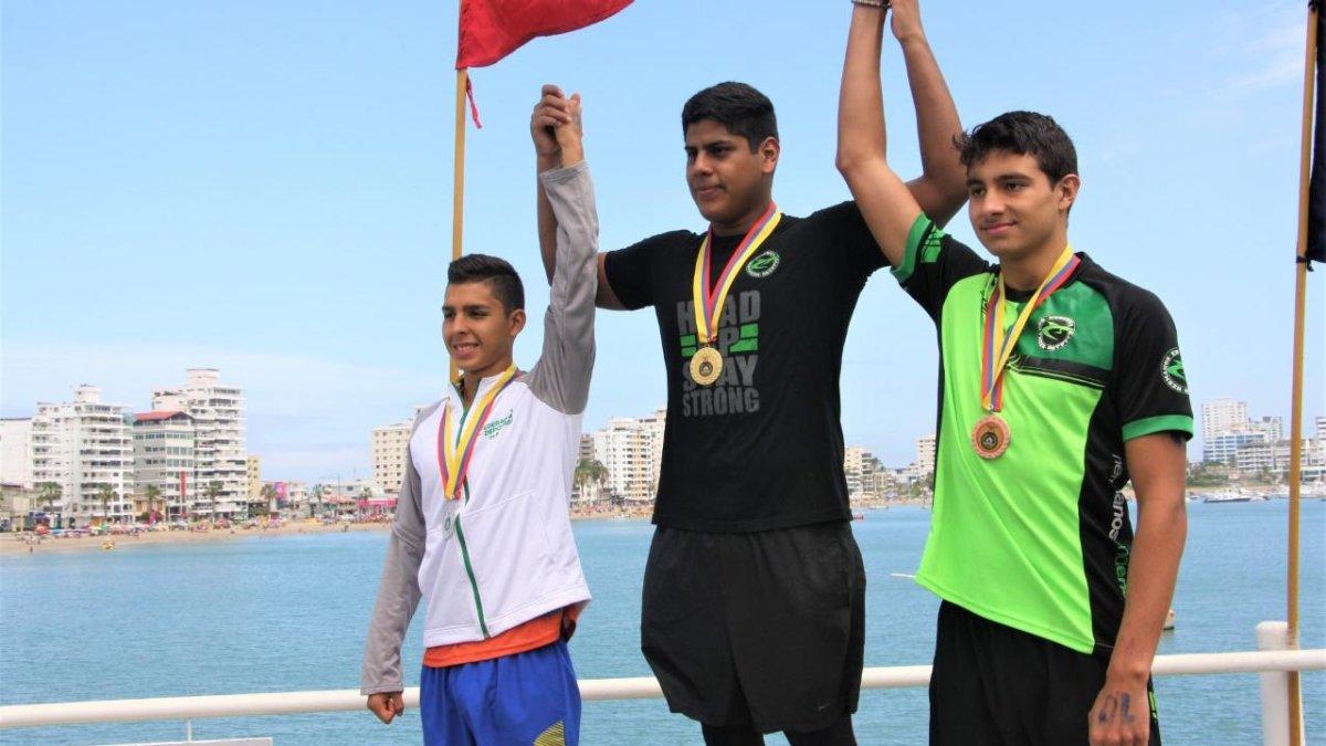 El nadador machaleño David Farinango (c) en el podio tras cronometrar 58 minutos con 44 segundos.