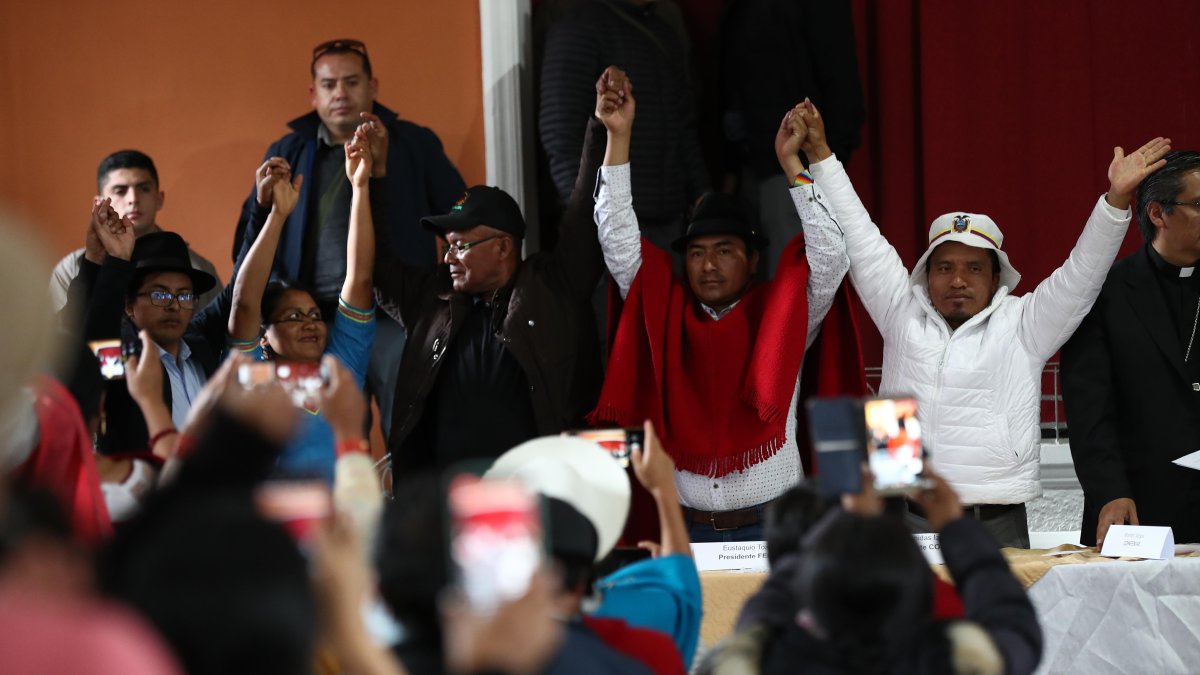El presidente de la Confederación de Nacionalidades Indígenas del Ecuador, Leonidas Iza (c), celebra tras la firma de un documento donde consta el acuerdo para detener el paro y las protestas en Ecuador, el 30 de junio de 2022, en la sede de la CEE, en Quito (Ecuador).