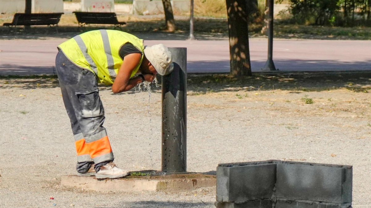 Un trabajador se refresca en una fuente de un parque de Lleida, este viernes en que todas las comarcas de Cataluña.