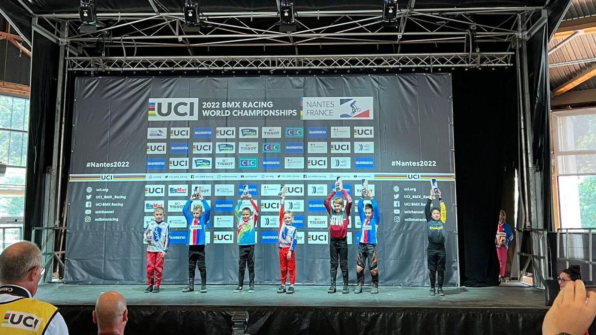 Tapia (d) levanta el trofeo de su categoría en el World Challenge de BMX en Italia.