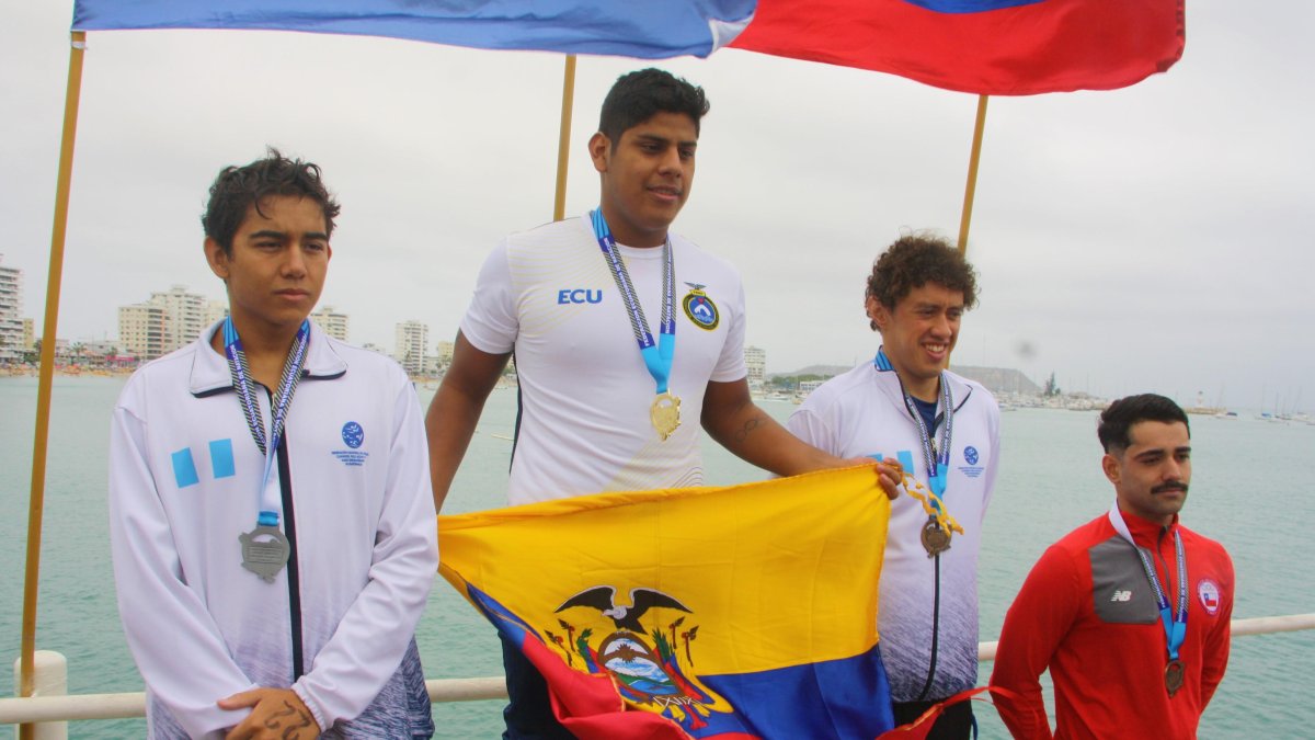 David Farinango (c), nadador ecuatoriano, muestra la bandera tricolor en el podio tras ganar la medalla de oro.
