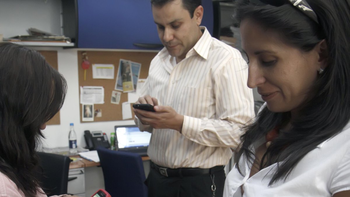 Comunicación.- Tres personas utilizan el internet móvil.