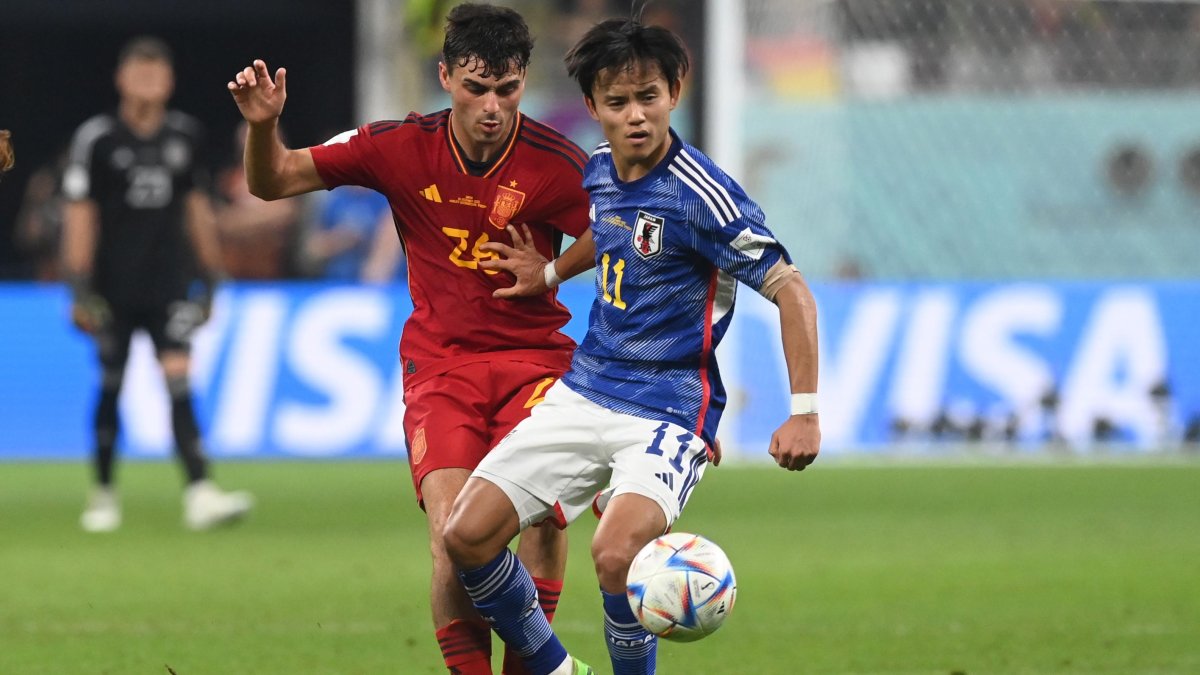 Takefusa Kubo (azul), volante de Japón, disputando una pelota con Pedri, mediocentro de España.
