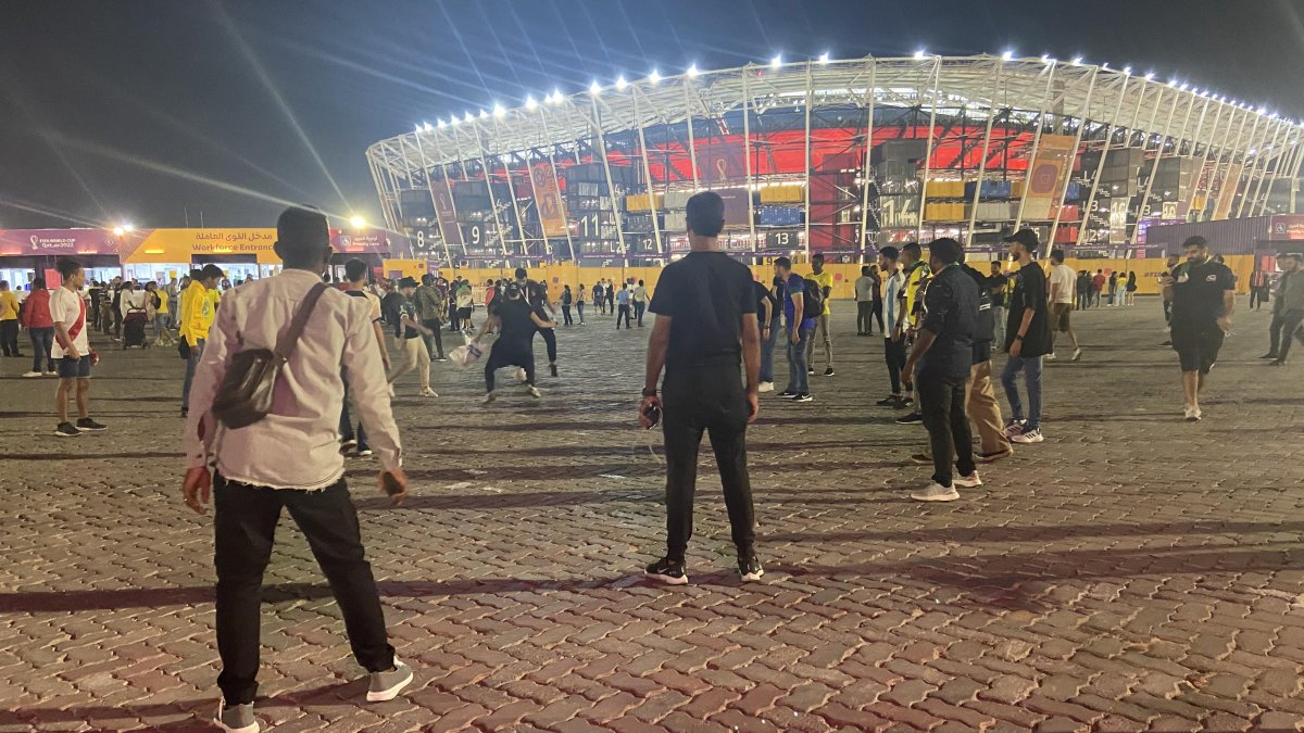 Hinchas cataríes y brasileños jugando un partido en las afueras del estadio 974 durante un cotejo oficial.