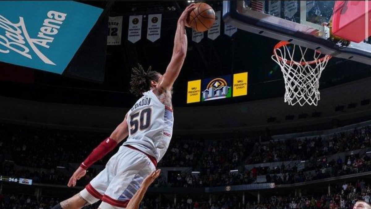 El basquetbolista mientras ejecutaba el tiro espectacular en el aire y con una sola mano.