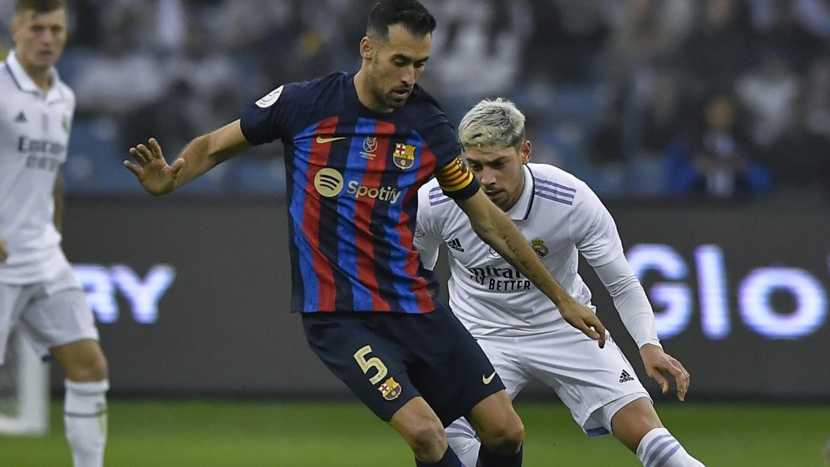 Sergio Busquets (i) de Barcelona y Federico Valverde del Real Madrid en una de las jugadas del domingo 15 de enero, durante la final.