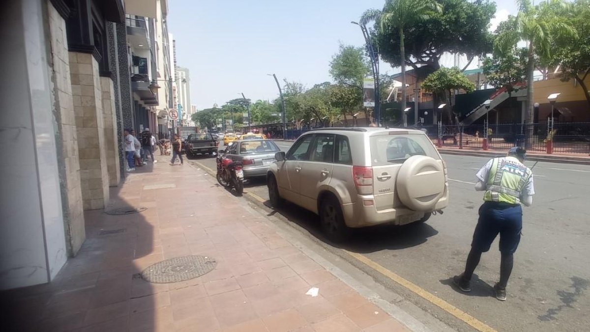 A pocos metros de los carros estacionados se encuentra una señalética de no parquear.