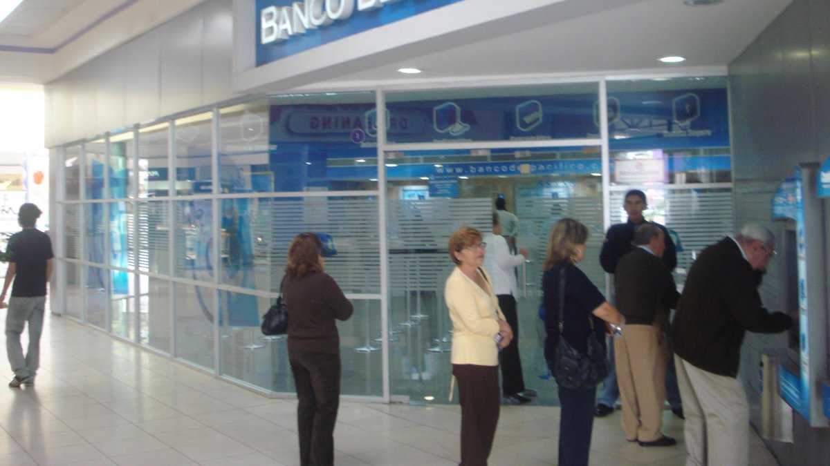 Usuarios.- Un grupo de personas usan los cajeros automáticos de un banco en Ecuador..