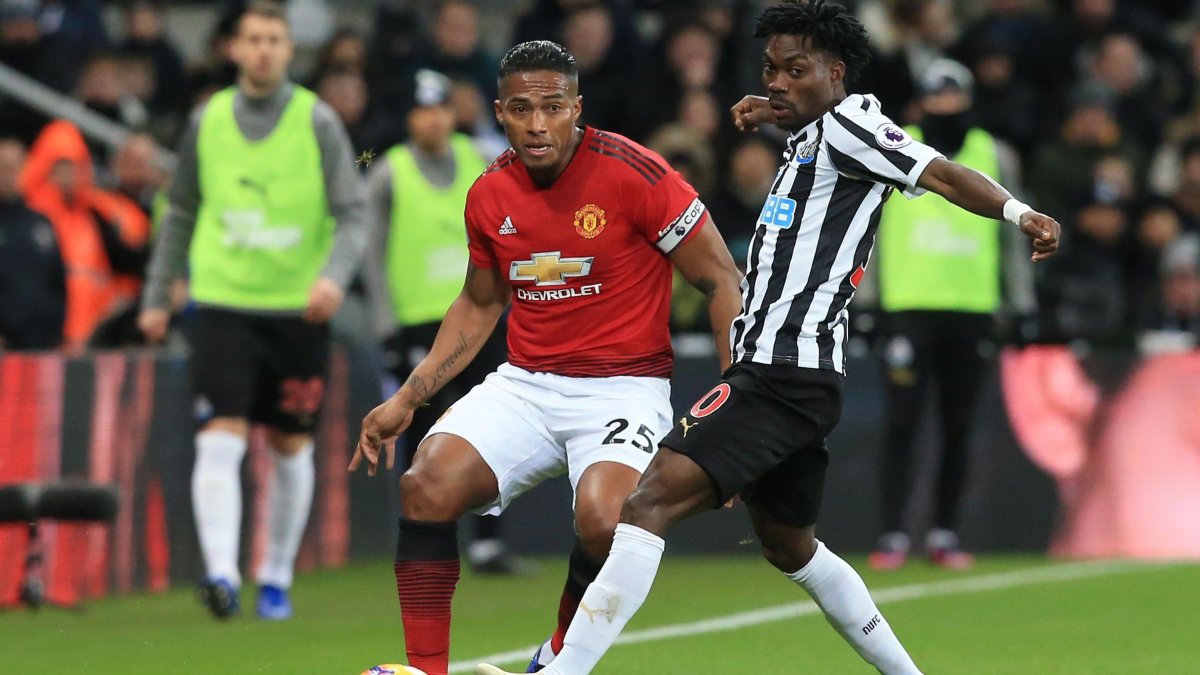 El ofensivo Christian Atsu (d) durante su paso por el Newcastle, disputa un balón con el extremo ecuatoriano Antonio Valencia (i).