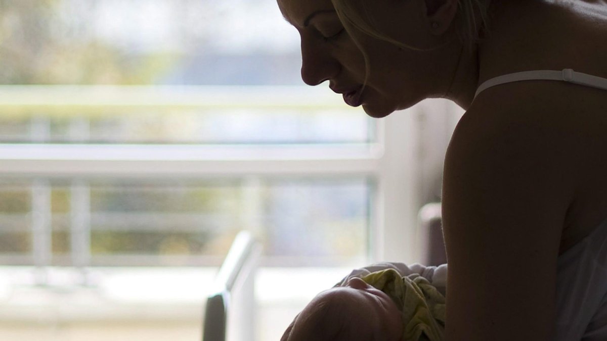 Costumbre. Una madre arrulla a un recién nacido al pie de su cuna.