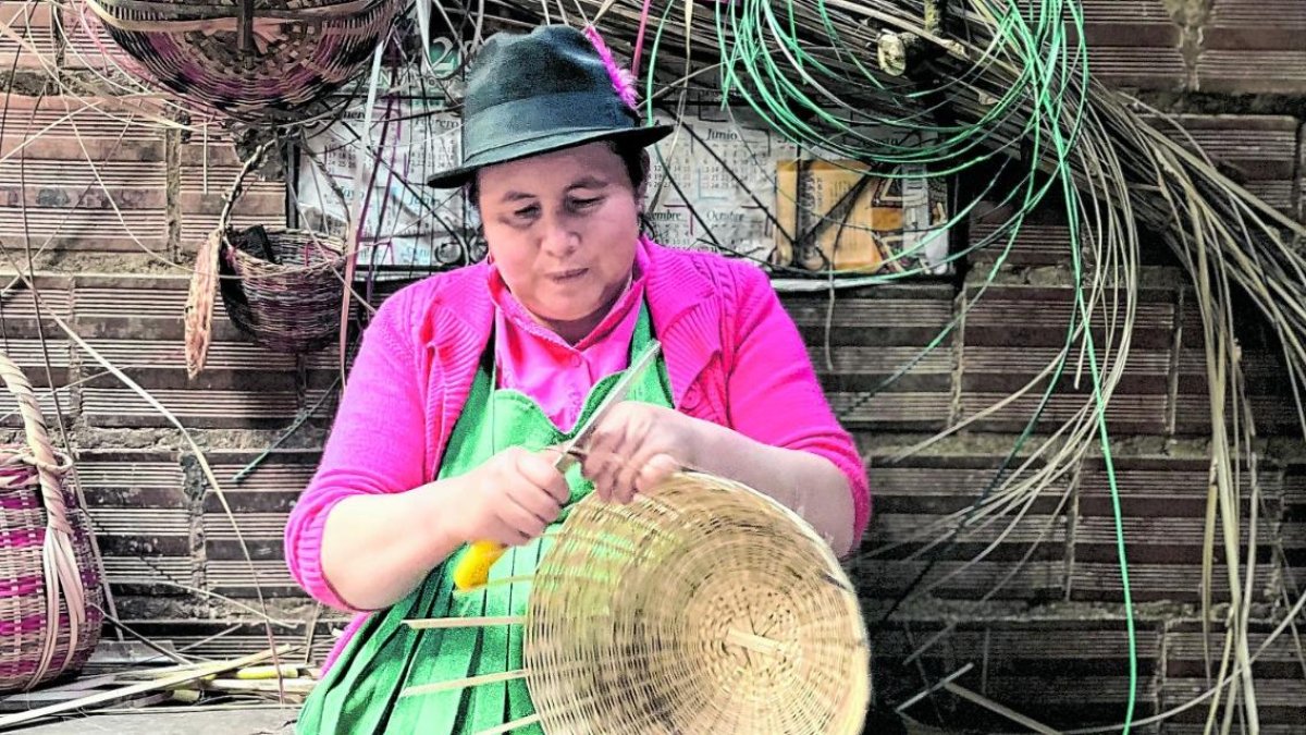 Arte. Una indígena confecciona una cesta artesanal.