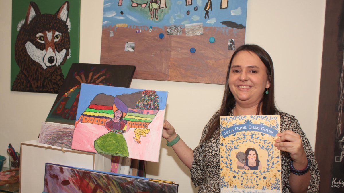 Autora. Karyna Abad Arteaga muestra su nuevo libro y uno de sus tantos cuadros que ha pintado.