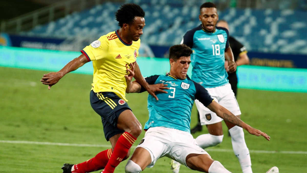 Juan Cuadrado (i) de Colombia disputa el balón con Piero Hincapié de Ecuador, en el empate 0-0 por eliminatorias.