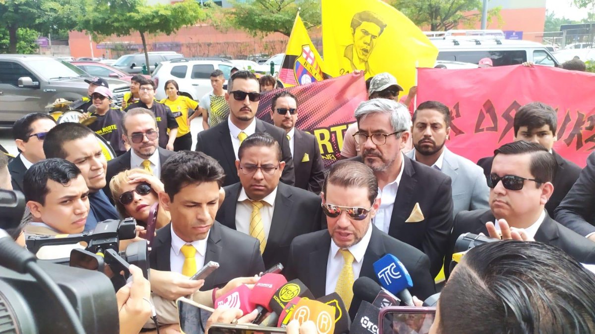 Rafael Verduga (C) atiende a los medios de comunicación en los exteriores del edificio XIMA, en Samborondón. A su izquierda, el exjugador y aspirante a la vicepresidencia de Barcelona, Matías Oyola.