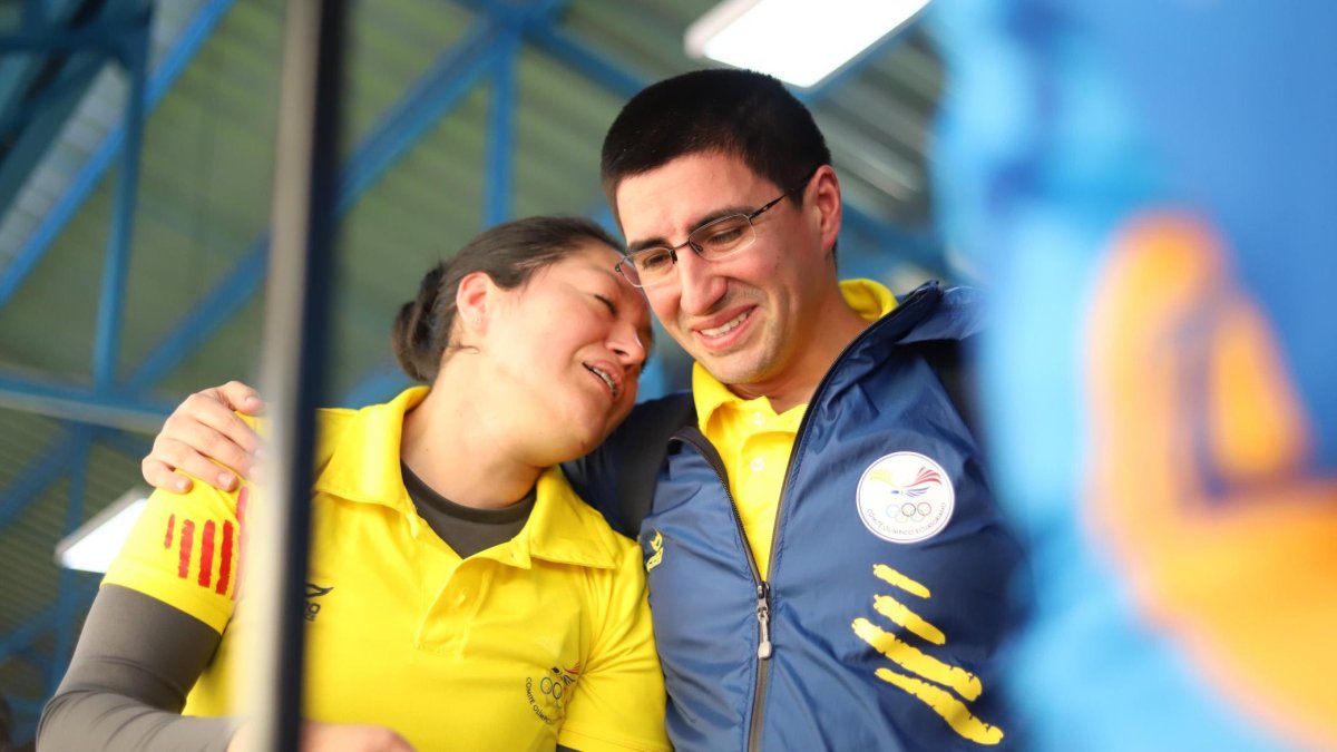 La tiradora olímpica Diana Durango, tras terminar la prueba y ser felicitada por su entrenador.