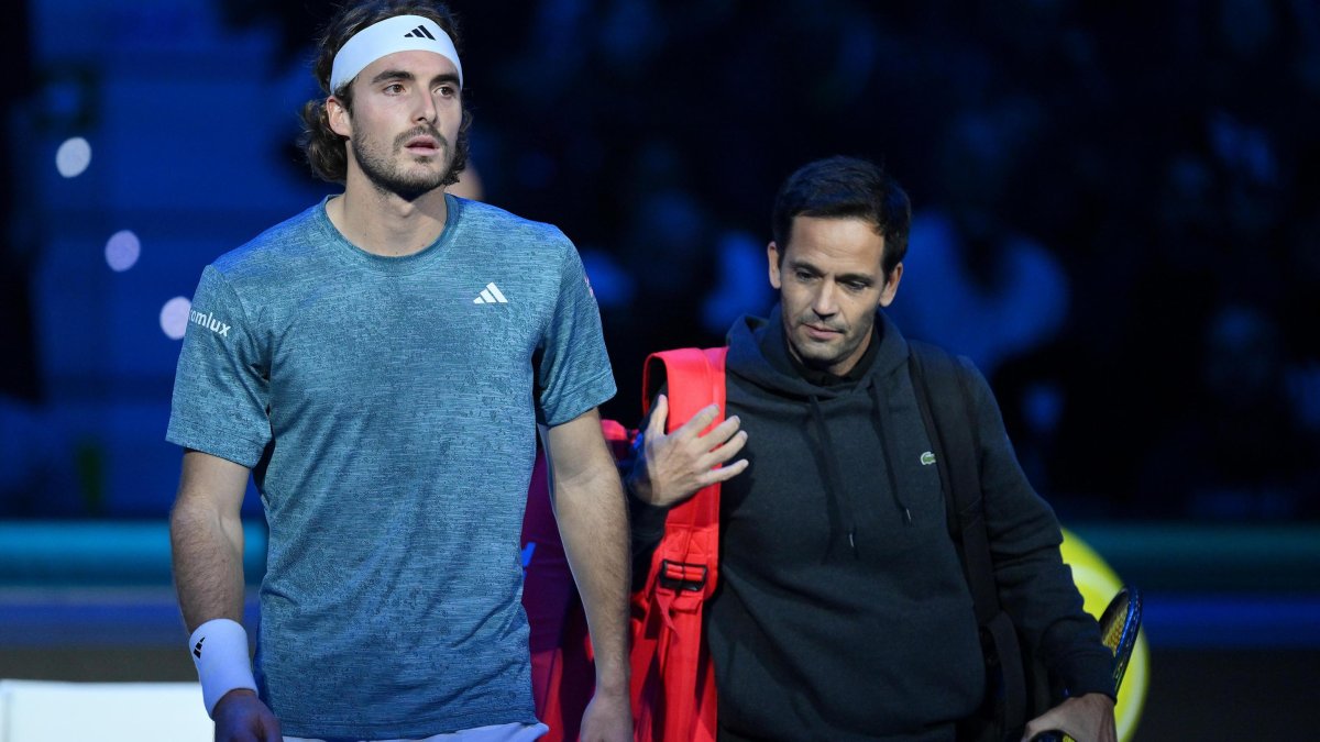 Stefanos Tsitsipas (i) de Grecia se retira durante su partido contra Holger Rune de Dinamarca en el torneo de tenis Nitto ATP Finals.