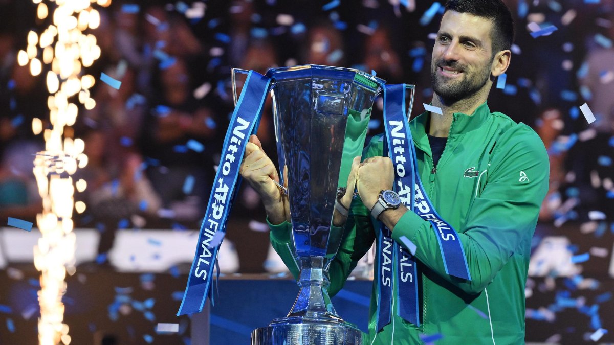 Novak Djokovic, de Serbia, posa con el trofeo después de ganar su partido final individual contra Jannik Sinner de Italia.
