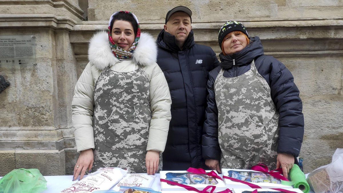 Oksana Mazar (d) y otros civiles de la Cocina de Voluntarios de Leópolis, que se centran en apoyar a los soldados en la línea del frente al enviarles raciones de comida seca, participan este lunes, en la feria de recaudación de fondos de la ciudad ucraniana.