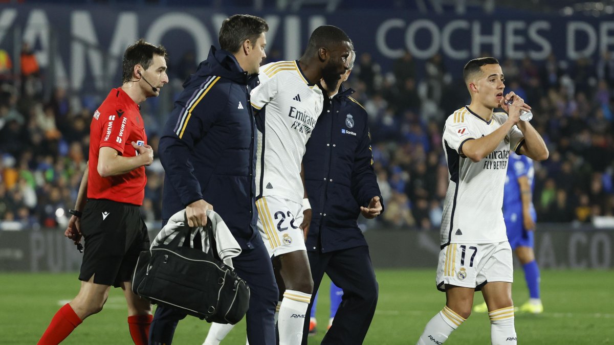 El defensa alemán del Real Madrid Antonio Rudiger (c) sale acompañado por los fisioterapeutas.