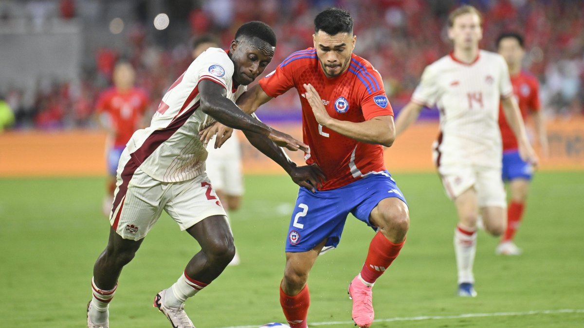 Richie Laryea de Canadá (i) en acción contra el chileno Gabriel Suazo durante un partido del grupo A.