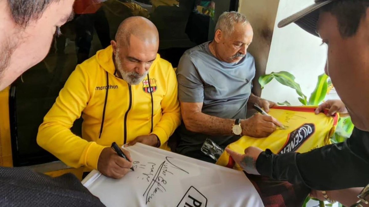 Magú firmando camisetas de Barcelona junto a Víctor Sphanor.