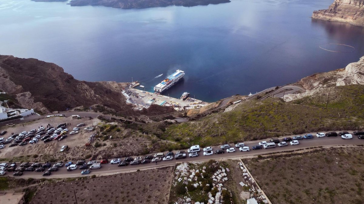 Residentes y visitantes de Santorini forman colas con sus coches hacia el puerto de Athinios, mientras abandonan la isla por el aumento de la actividad sísmica de los últimos días.