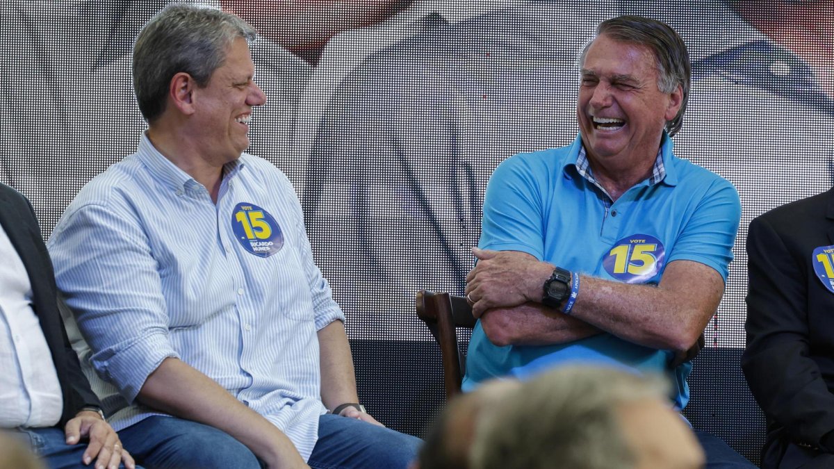 El expresidente ultraderechista brasileño Jair Bolsonaro (2019-2022) (d) ríe junto al gobernador del estado de Sao Paulo, Tarcísio de Freitas (i), durante un acto de campaña.