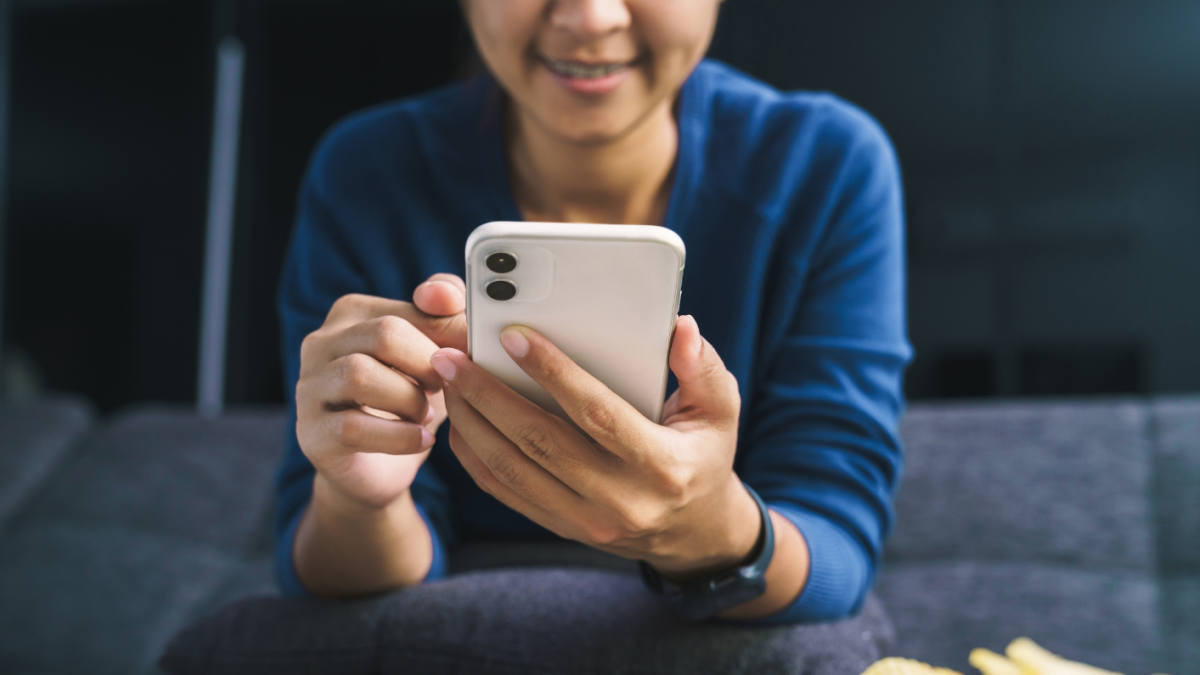 Una persona al manipular un teléfono celular. Referencial.