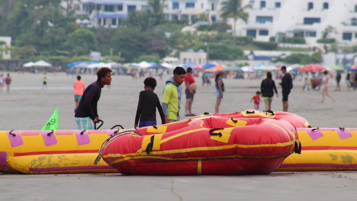 Operadores turísticos en Same, Atacames, preparan equipos para actividades acuáticas mientras ajustan sus jornadas ante el inminente toque de queda.
