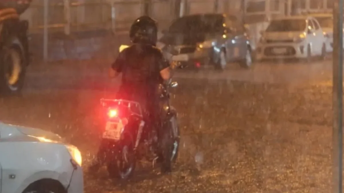 Vehículos circulan por una de las calles afectadas por la acumulación de agua en el norte de Guayaquil.