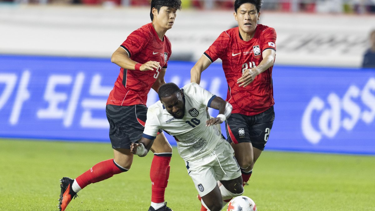 John Yeboah de Ecuador (C) cae ante la marca de Kim Bong-soo (d) y Kim Tae-hyeon de Corea del Sur el jueves pasado.