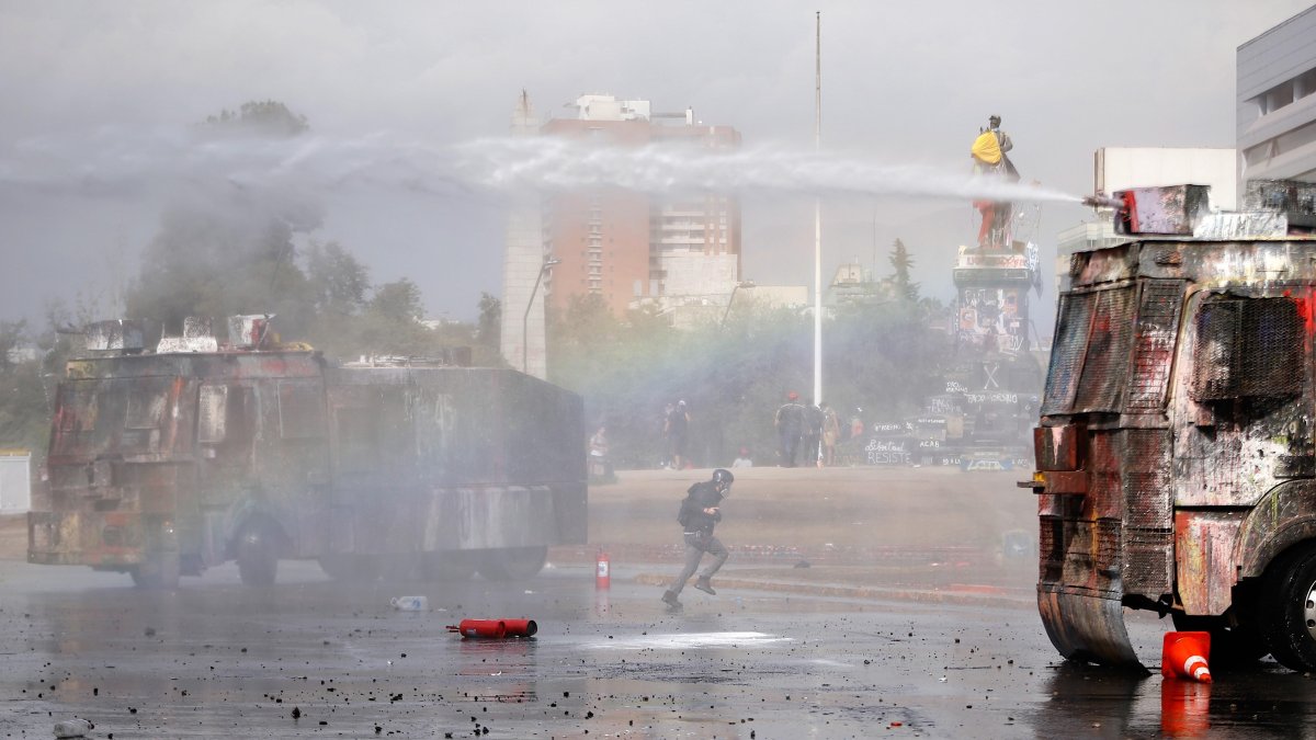 SANTIAGO. Fuerzas Especiales de Carabineros dispersan a un grupo de manifestantes este domingo en la céntrica plaza Italia de Santiago (Chile), rebautizada popularmente como Plaza de la Dignidad.