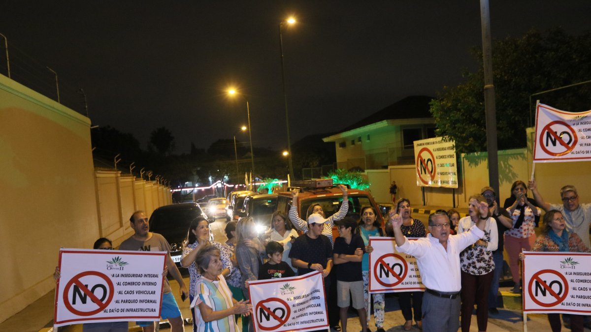 Residentes de la ciudadela Los Olivos 2 protestan con pancartas.