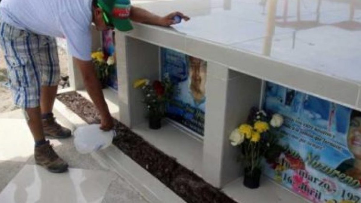 Jaime Macías señala el nombre de su madre en el memorial ubicado en el centro de Tarqui, Manta.