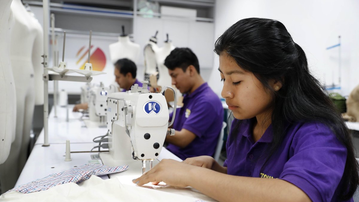 Una de las alumnas muestra la prenda creada para los niños quemados.