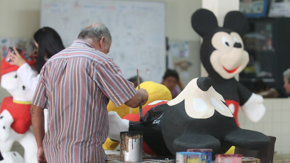 Usuarios del Instituto de Neurociencias, de la Junta de Beneficencia,construyen monigotes para la venta.